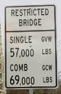 Restricted bridge sign reading Single 57 thousand pounds and combination 69 thousand pounds.